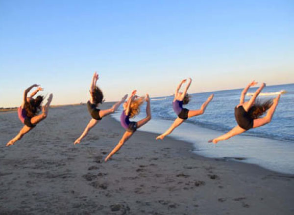 about us - photo of girls dancing on the beach